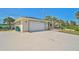 A wide, well-maintained driveway leads to a two-car garage, complemented by lush landscaping and mature palm trees at 801 E 5Th St, Englewood, FL 34223