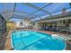 This screened-in pool features a covered area with an outdoor kitchen and easy access to the lanai at 801 E 5Th St, Englewood, FL 34223