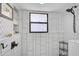 Beautiful shower with a rain shower head, and stylish white tile, and built in shelving at 801 E 5Th St, Englewood, FL 34223