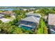Aerial view of the property features a screened pool, lush landscaping, and tile roof at 801 Seascape Pl, Sarasota, FL 34240