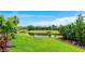 Lush backyard view featuring a serene pond and well-manicured lawn at 801 Seascape Pl, Sarasota, FL 34240
