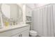 Bathroom featuring a round mirror, vanity, and a shower with striped curtains at 801 Seascape Pl, Sarasota, FL 34240