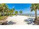 Community beach area with sand, palm trees, and lake views at 801 Seascape Pl, Sarasota, FL 34240
