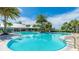 Community pool with lounge chairs, sun umbrellas, and lake view at 801 Seascape Pl, Sarasota, FL 34240