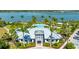 Aerial view of the community clubhouse and pool surrounded by palm trees near the lake at 801 Seascape Pl, Sarasota, FL 34240