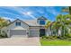 Beautiful single-Gathering home featuring a three-car garage, stone accents, and lush landscaping at 801 Seascape Pl, Sarasota, FL 34240