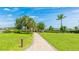 Beautifully landscaped community grounds with a paver path and tropical trees under a bright blue sky at 801 Seascape Pl, Sarasota, FL 34240