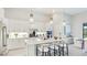 Modern kitchen with a spacious island, white cabinets, stainless steel appliances, and pendant lights at 801 Seascape Pl, Sarasota, FL 34240