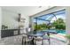 Outdoor kitchen featuring modern appliances with a view of the pool and seating area at 801 Seascape Pl, Sarasota, FL 34240