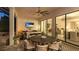 Inviting outdoor seating and dining area with a ceiling fan, TV and seamless access to indoor spaces at 801 Seascape Pl, Sarasota, FL 34240