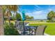 Outdoor seating area with lake view, featuring comfortable seating and a vibrant turquoise umbrella at 801 Seascape Pl, Sarasota, FL 34240