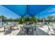 Outdoor patio with tables and chairs offers shade and tennis court views at 801 Seascape Pl, Sarasota, FL 34240