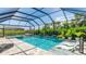 Backyard oasis featuring a screened-in pool with a spa, lounge chairs, and tropical landscaping at 801 Seascape Pl, Sarasota, FL 34240