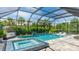 Inviting screened-in pool area with a hot tub, lounge chairs, and lush landscaping at 801 Seascape Pl, Sarasota, FL 34240