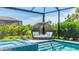 Gorgeous screened-in pool area featuring a unique, cushioned outdoor lounge and tile accents at 801 Seascape Pl, Sarasota, FL 34240