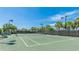Outdoor tennis court under blue skies surrounded by palm trees and landscaping at 801 Seascape Pl, Sarasota, FL 34240