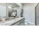 Modern bathroom featuring double sinks, granite countertops, a large mirror, and a glass-enclosed shower at 805 157Th E Ct, Bradenton, FL 34212