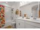 Bright bathroom with double sink vanity, shower over tub, and colorful shower curtain at 8612 Evening Dr, Sarasota, FL 34241