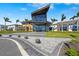Exterior of a modern clubhouse with large windows, manicured landscaping, and palm trees against a blue sky at 8612 Evening Dr, Sarasota, FL 34241