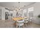 Open-concept dining area and kitchen featuring a stylish light fixture and seating for six at 8612 Evening Dr, Sarasota, FL 34241