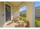 Inviting front porch featuring neutral furniture, decorative plants, and a charming wreath on the front door at 8612 Evening Dr, Sarasota, FL 34241