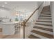 Bright open kitchen with stainless steel appliances, breakfast bar, dining area, and staircase at 8612 Evening Dr, Sarasota, FL 34241
