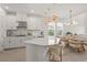 Bright, open kitchen with white cabinetry, quartz countertops, stainless steel appliances, and stylish pendant lighting at 8612 Evening Dr, Sarasota, FL 34241