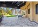 Outdoor patio with a ping pong table, pavers, wood-paneled walls, and views of a lush green space at 8612 Evening Dr, Sarasota, FL 34241