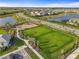 Aerial shot of a community playground with green spaces, a dog park, and walking paths at 8612 Evening Dr, Sarasota, FL 34241