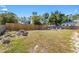 Spacious backyard featuring a wood fence, mature trees, and outdoor seating at 1010 Tropical Dr, Bradenton, FL 34208