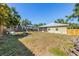 Large backyard with a wooden fence, seating area, and view of the home's exterior at 1010 Tropical Dr, Bradenton, FL 34208