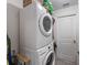 Bright laundry area with stacked washer and dryer, and storage solutions at 1010 Tropical Dr, Bradenton, FL 34208