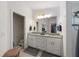 Bright bathroom featuring a dual sink vanity, and a glass-enclosed shower at 1010 Tropical Dr, Bradenton, FL 34208