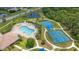 Aerial view of community pool, tennis courts, playground, sidewalks, landscaping, and pond at 1034 Buttercup Gln, Bradenton, FL 34212