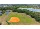 Aerial view of the community baseball field surrounded by grass and trees at 1034 Buttercup Gln, Bradenton, FL 34212