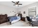 Bedroom with a dark wood bed frame, ceiling fan, dresser, and desk set up at 1034 Buttercup Gln, Bradenton, FL 34212