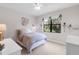 Bedroom with a white bed frame, white end tables, and a large window at 1034 Buttercup Gln, Bradenton, FL 34212