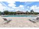 Community pool surrounded by lounge chairs and umbrellas, perfect for relaxing in the sun at 1034 Buttercup Gln, Bradenton, FL 34212