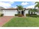 Charming single-story home with lush landscaping, brick driveway, and attached two-car garage at 1034 Buttercup Gln, Bradenton, FL 34212