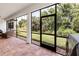 Screened-in patio with brick floor offers serene backyard views through screen at 1034 Buttercup Gln, Bradenton, FL 34212