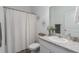 Bright bathroom with a single sink vanity, decorative mirror, and shower with curtain at 10464 Ladybug Cv, Parrish, FL 34219