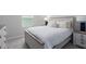 Bedroom with a comfy bed, bedside tables, and a window letting in natural light at 10464 Ladybug Cv, Parrish, FL 34219