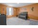 Bedroom featuring a crib, orange accent wall, carpet, and white trim at 10464 Ladybug Cv, Parrish, FL 34219