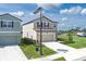 Two-story home with beige siding, a two-car garage, and a well-manicured front lawn at 10464 Ladybug Cv, Parrish, FL 34219