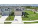 Two-story home with beige siding, a two-car garage, and a well-manicured front lawn at 10464 Ladybug Cv, Parrish, FL 34219