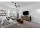 Comfortable living room with modern furniture, large windows, and stylish decorative shelves at 10464 Ladybug Cv, Parrish, FL 34219