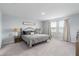 Large bedroom with a comfortable bed, stylish lamps, and a large window at 10464 Ladybug Cv, Parrish, FL 34219