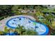 Community splash pad featuring colorful water features, a playground, and surrounding tropical landscaping at 10464 Ladybug Cv, Parrish, FL 34219