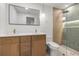 Modern bathroom featuring double vanity, stylish lighting, and glass-enclosed shower with sleek gold fixtures at 1052 Concord W Dr, Dunedin, FL 34698