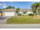 Well-maintained home featuring a stone facade garage, lush lawn, and mature palm trees in desirable area at 1104 76Th Nw St, Bradenton, FL 34209
